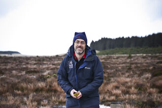 Duncan standing on a wetland