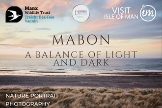 A photo of two women stood on marram grass covered sand dunes at dusk.
