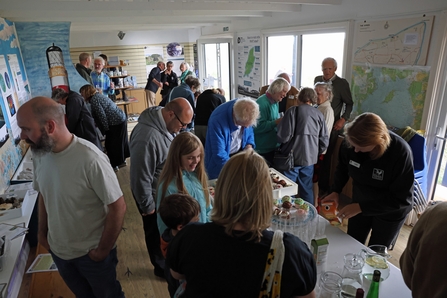 A group of people looking at lots of different things inside the Ayres Nature Discovery Centre