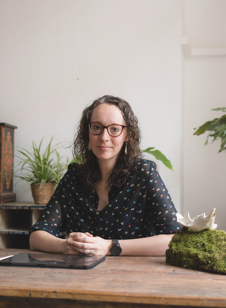 Ali MWT Artist in Residence sat at a wooden table